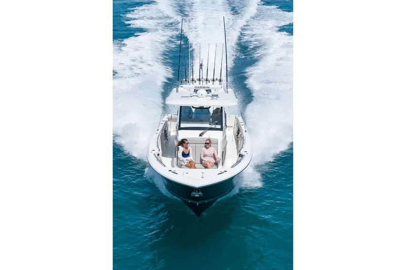 Slide: The Image of 2026 Pursuit S 358 Sport boat cruising on clear blue water with passengers onboard. - 3