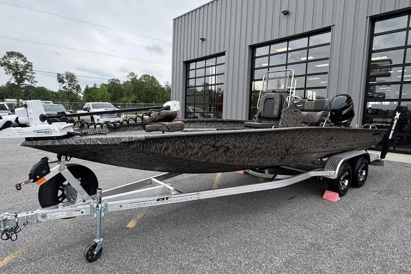 The Image of 2026 Xpress H22B Bay boat on trailer outside a modern building. - 1