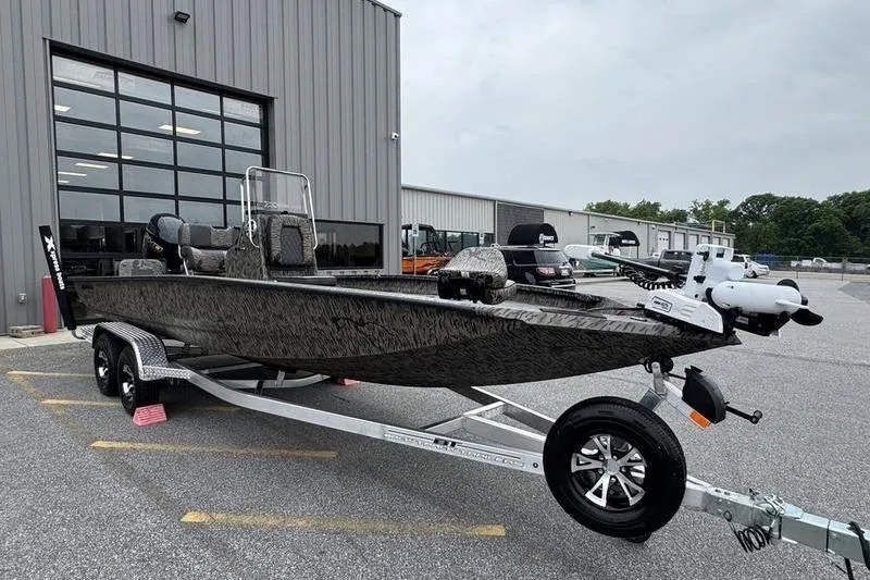 Slide: The Image of 2026 Xpress H22B Bay boat on trailer outside industrial building. - 21