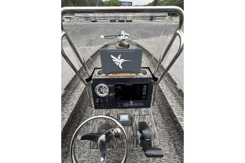 Slide: The Image of 2026 Xpress H22B Bay boat dashboard with steering wheel and navigation controls. - 22