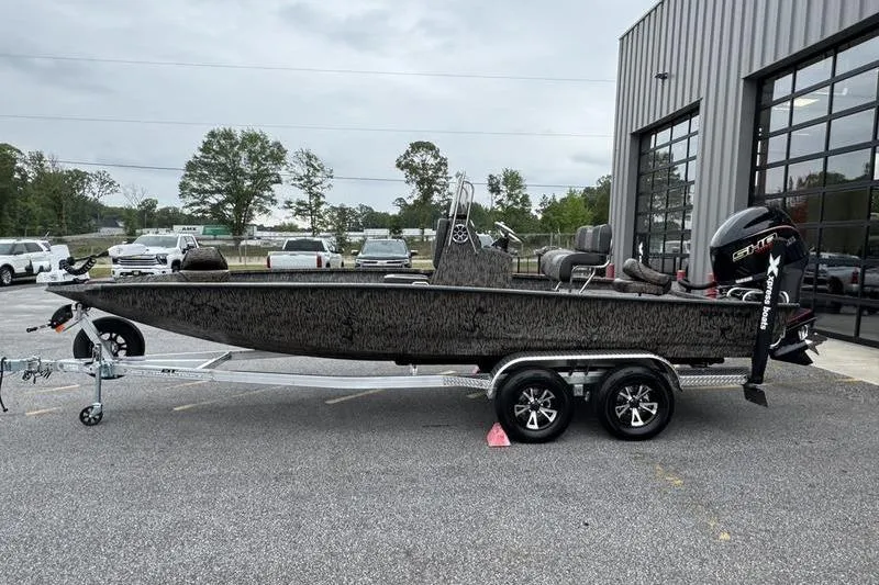 Slide: The Image of 2026 Xpress H22B Bay boat on trailer, parked outside a building. - 4