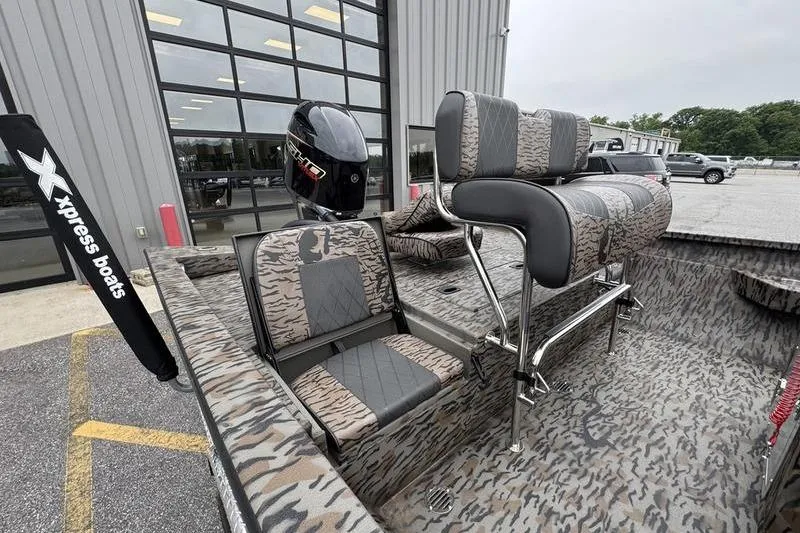 Slide: The Image of 2026 Xpress H22B Bay boat with camo seating and powerful outboard motor. - 5