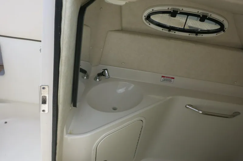 Slide: The Image of Interior of 2008 Sea Ray 260 Sundeck boat, featuring a compact sink and porthole window. - 12