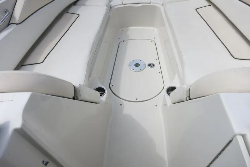 Slide: The Image of 2008 Sea Ray 260 Sundeck interior seating area with white upholstery and cup holders. - 16