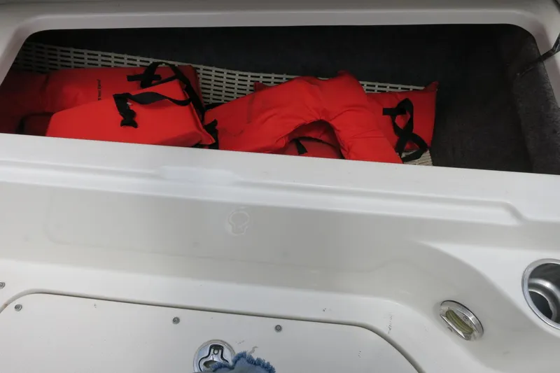 Slide: The Image of Storage compartment with red life jackets on a 2008 Sea Ray 260 Sundeck boat. - 17