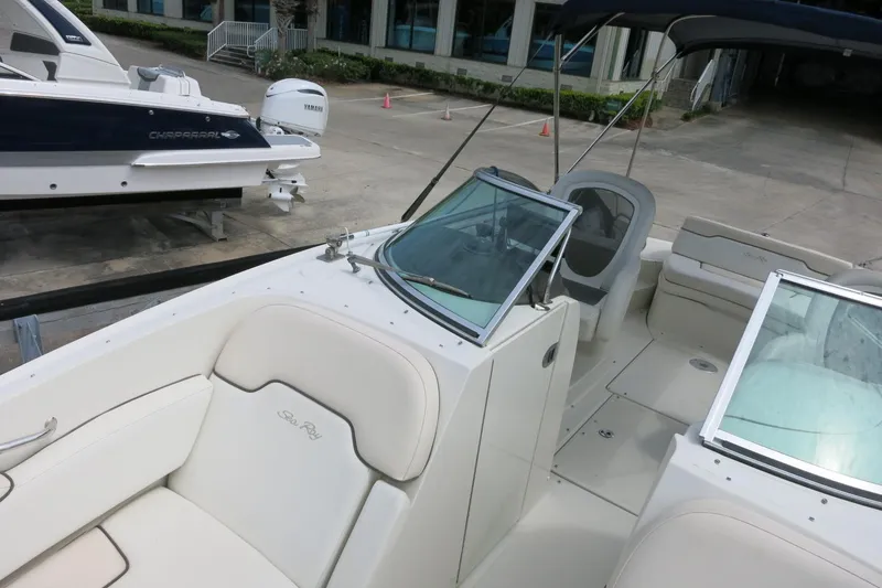 Slide: The Image of 2008 Sea Ray 260 Sundeck boat interior with seating and windshield, docked near another vessel. - 24