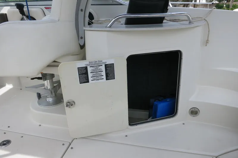 Slide: The Image of 2008 Sea Ray 260 Sundeck interior with open storage compartment and seating area. - 33
