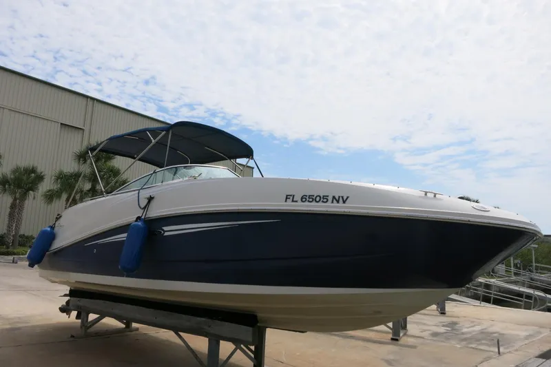 Slide: The Image of 2008 Sea Ray 260 Sundeck boat on a lift, blue hull, canopy, dockside view. - 4