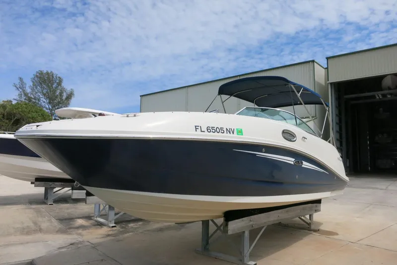 Slide: The Image of 2008 Sea Ray 260 Sundeck boat with blue hull, docked outdoors under a clear sky. - 5