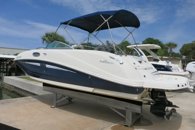Slide: The Image of 2008 Sea Ray 260 Sundeck boat with blue and white exterior on a lift. - 6