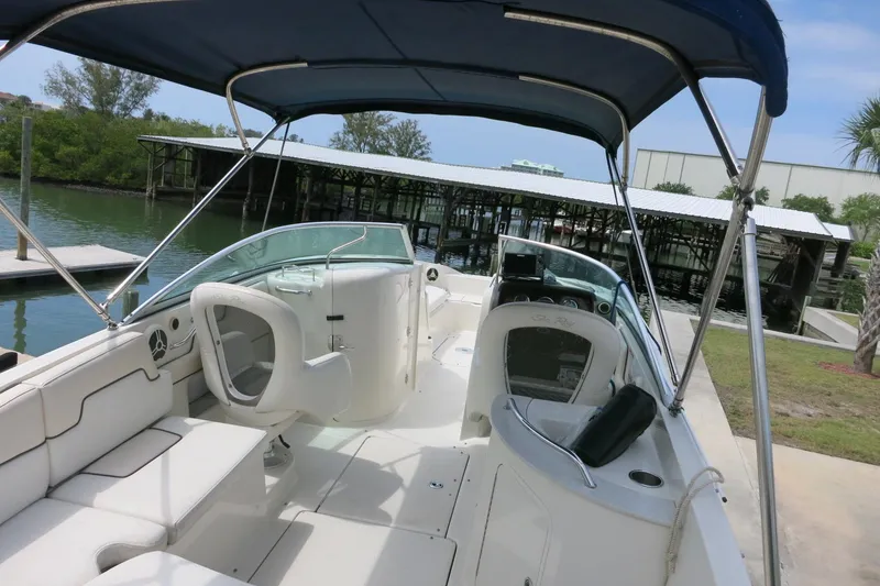 Slide: The Image of 2008 Sea Ray 260 Sundeck boat interior with canopy, docked near a marina. - 8