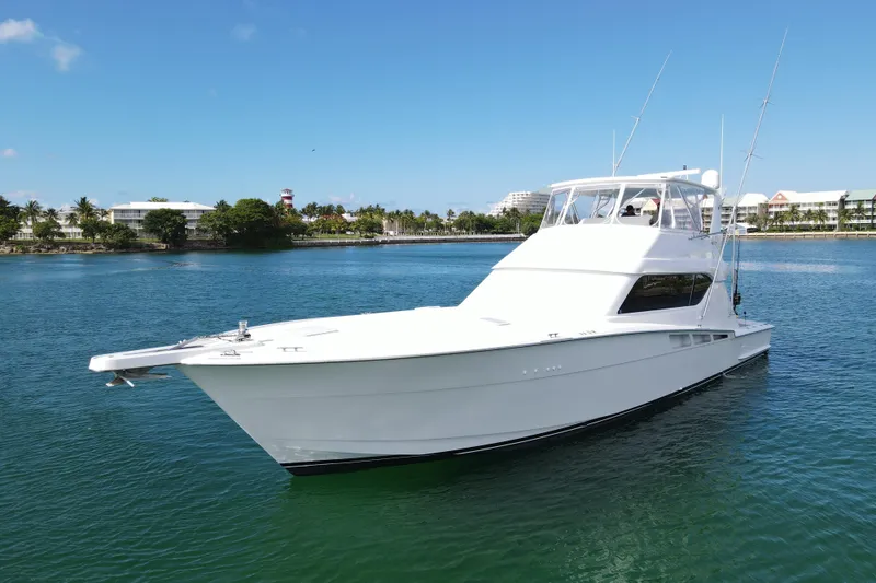 Slide: The Image of 2004 Hatteras 60 Convertible yacht on calm water, clear sky background. - 18