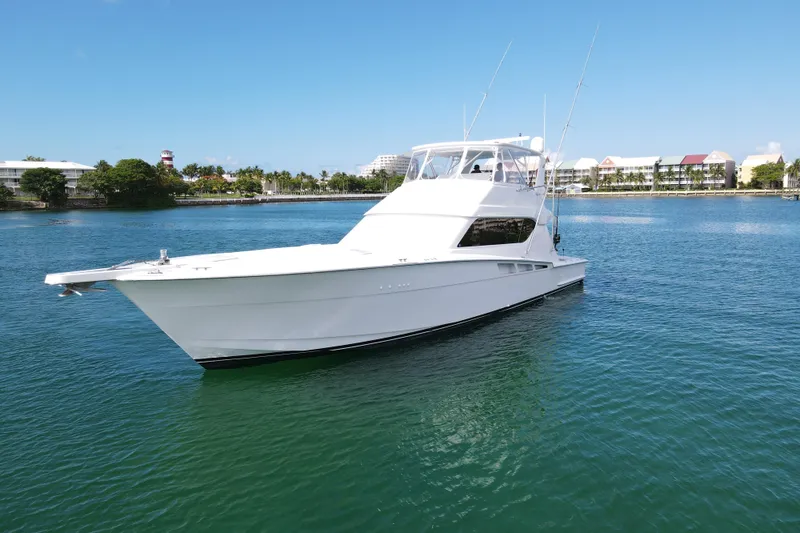 Slide: The Image of 2004 Hatteras 60 Convertible yacht on calm water, clear sky background. - 20