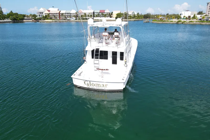Slide: The Image of 2004 Hatteras 60 Convertible yacht cruising in a serene marina setting. - 34
