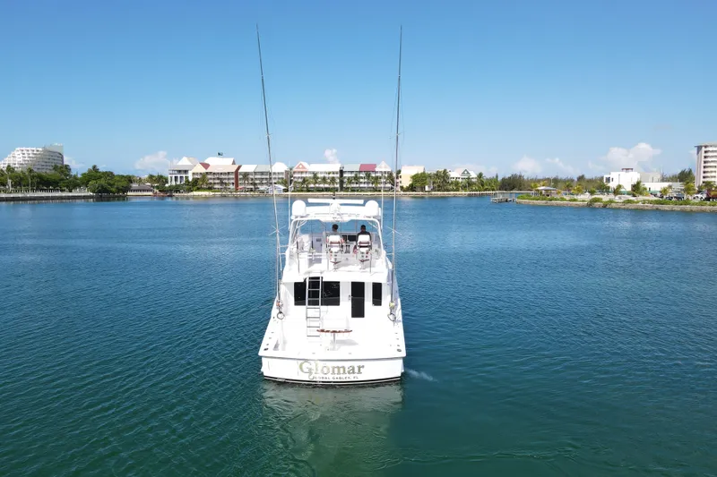 Slide: The Image of 2004 Hatteras 60 Convertible yacht cruising in a scenic waterfront area. - 36
