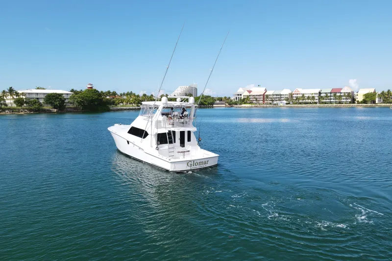 Slide: The Image of 2004 Hatteras 60 Convertible yacht cruising on a serene blue waterway. - 37