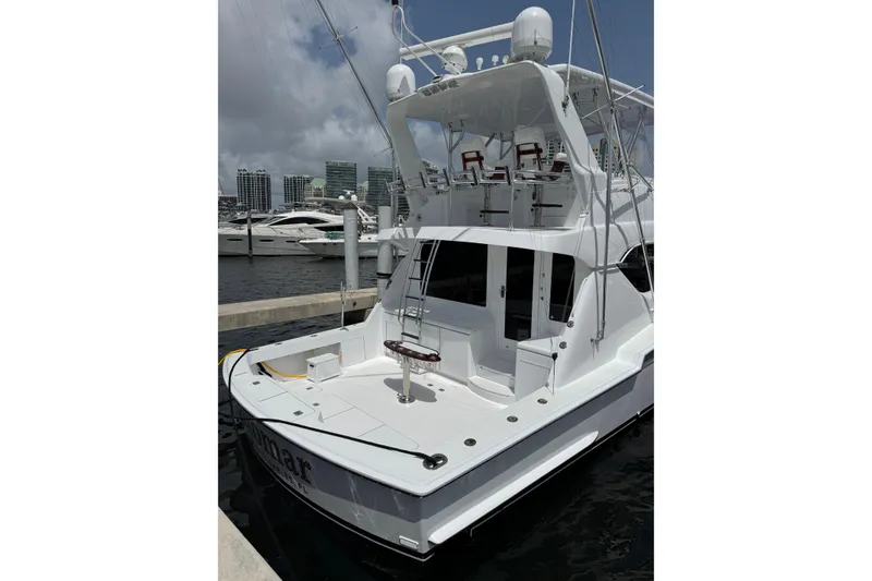 Slide: The Image of 2004 Hatteras 60 Convertible yacht docked at marina under cloudy sky. - 40