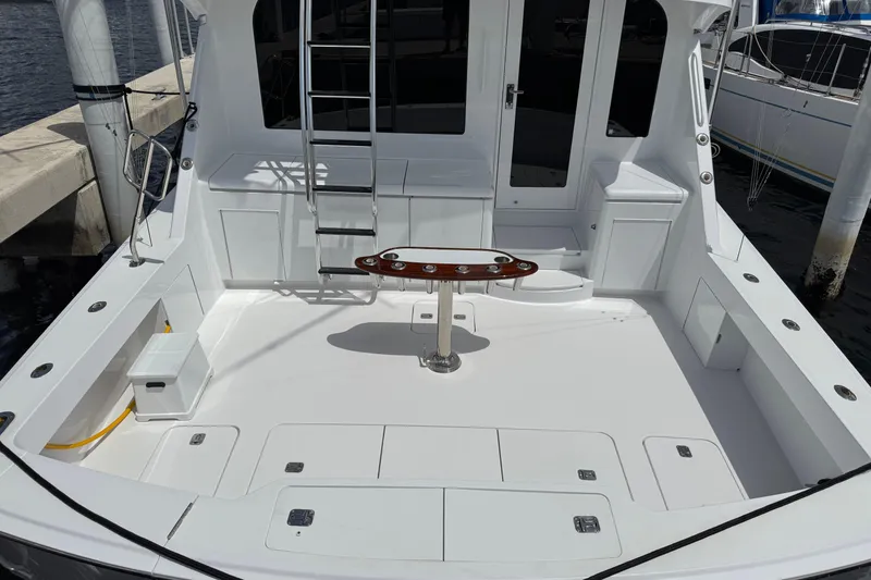 Slide: The Image of 2004 Hatteras 60 Convertible yacht cockpit with ladder and seating, docked at marina. - 42