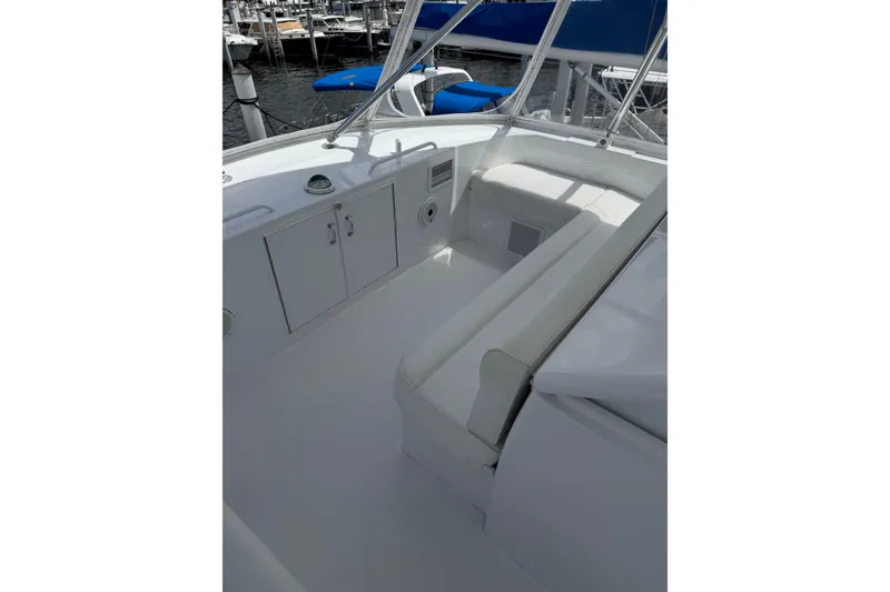 Slide: The Image of 2004 Hatteras 60 Convertible yacht cockpit with white seating and storage cabinets. - 44