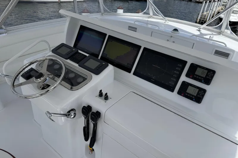 Slide: The Image of Helm of 2004 Hatteras 60 Convertible yacht with advanced navigation displays and controls. - 49
