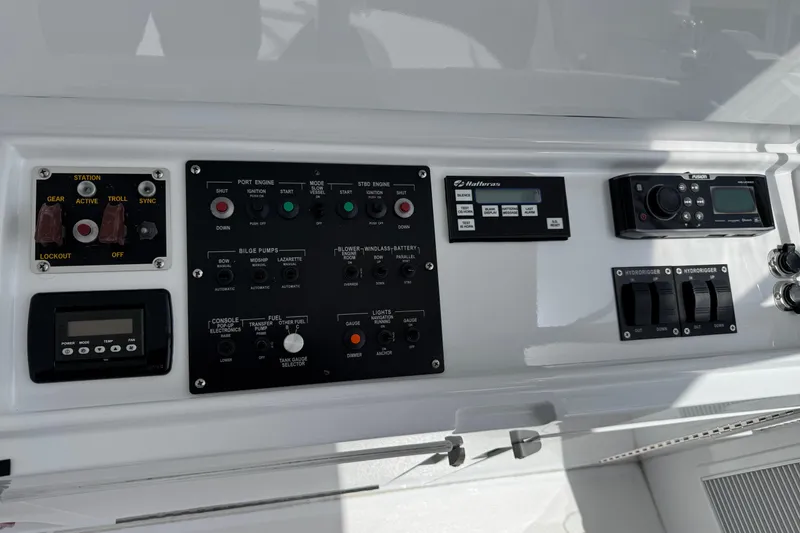 Slide: The Image of Control panel of a 2004 Hatteras 60 Convertible yacht, featuring various switches and displays. - 51