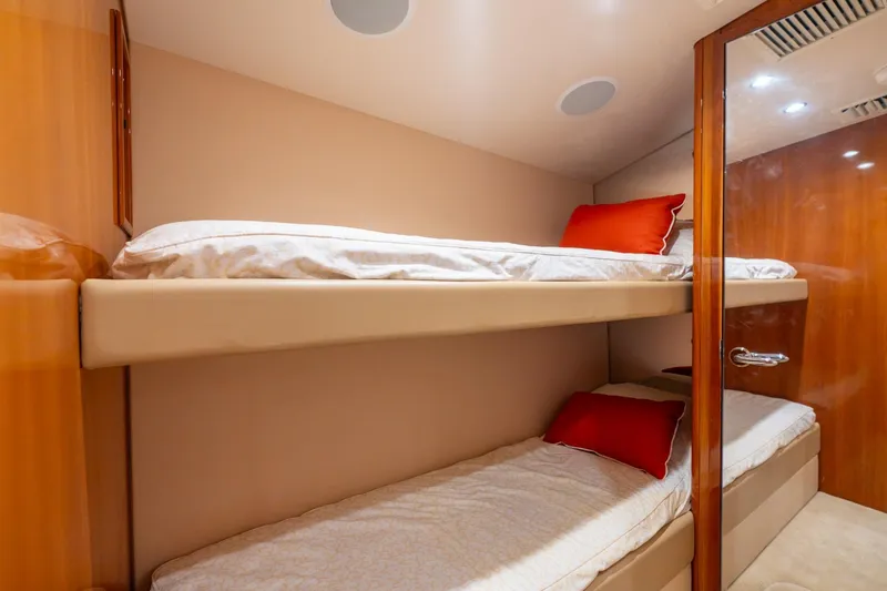 Slide: The Image of Bunk beds in 2004 Hatteras 60 Convertible yacht cabin with red pillows and wooden accents. - 32