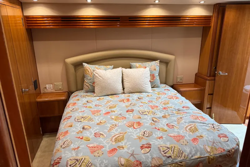 Slide: The Image of Luxurious bedroom interior of 2004 Hatteras 60 Convertible yacht with seashell-themed bedding. - 62