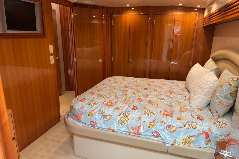 Slide: The Image of Luxurious bedroom interior of 2004 Hatteras 60 Convertible yacht with seashell-themed bedding. - 64