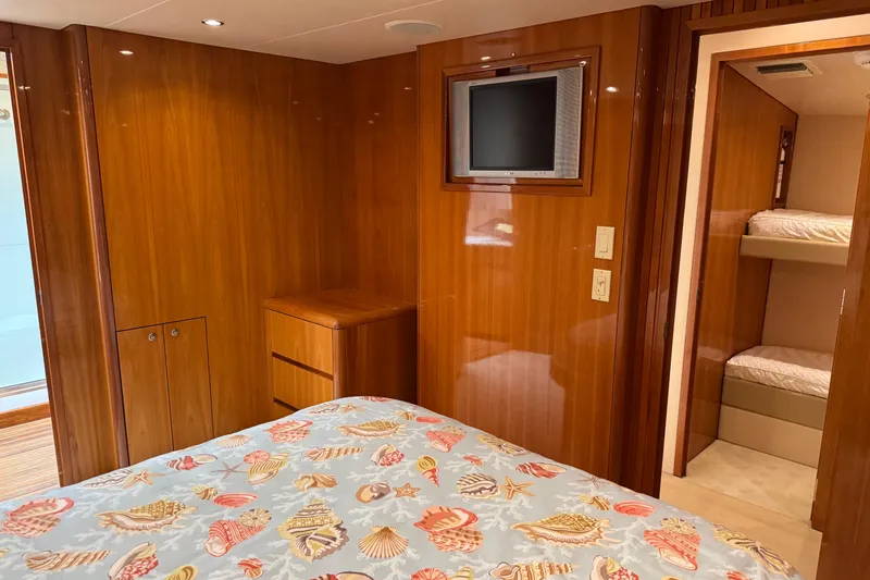 Slide: The Image of Luxurious 2004 Hatteras 60 Convertible yacht bedroom with wood paneling and cozy bedding. - 65