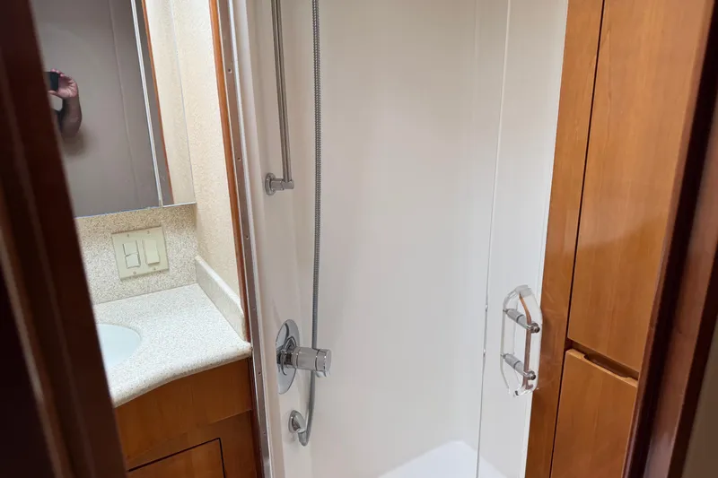 Slide: The Image of Bathroom interior of 2004 Hatteras 60 Convertible yacht with shower and wooden cabinetry. - 69