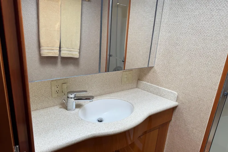 Slide: The Image of Bathroom vanity with sink and mirror in 2004 Hatteras 60 Convertible yacht. - 70