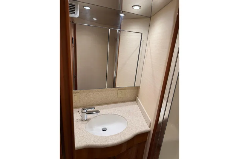 Slide: The Image of Luxurious bathroom vanity in 2004 Hatteras 60 Convertible yacht, featuring modern sink and mirror. - 72