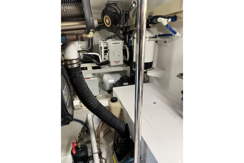 Slide: The Image of Engine room of 2004 Hatteras 60 Convertible yacht, showcasing mechanical components and equipment. - 74