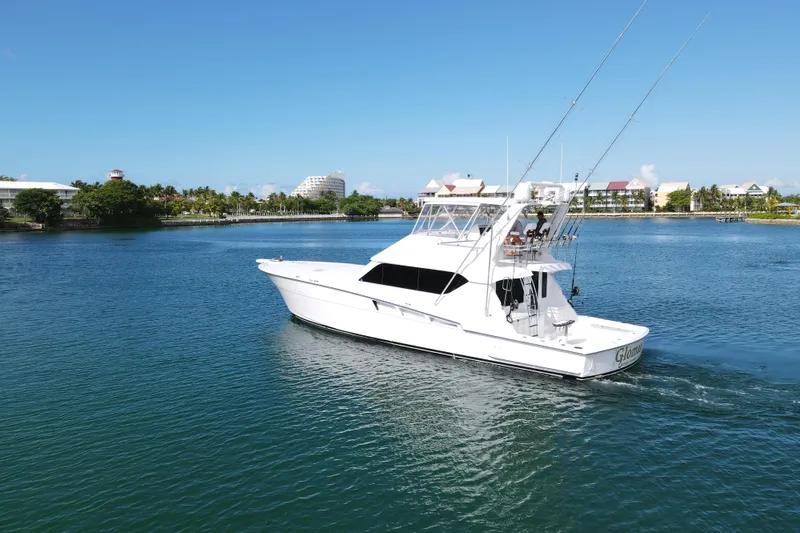 Slide: The Image of 2004 Hatteras 60 Convertible yacht cruising in a scenic waterfront setting. - 8