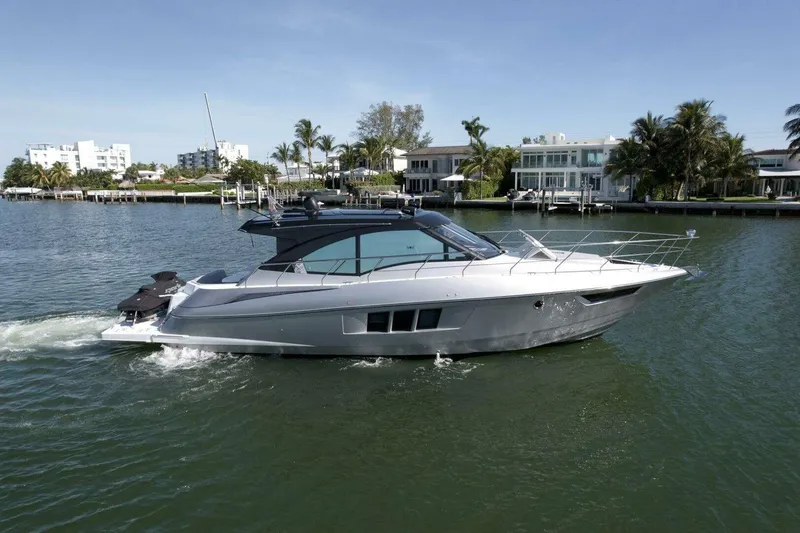 Slide: The Image of 2018 Cruisers Cantius 45 yacht cruising on a scenic waterfront with luxury homes. - 3