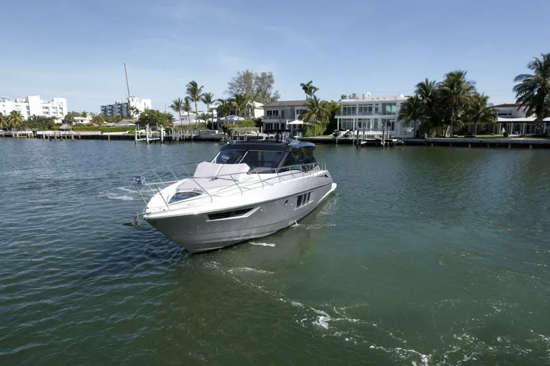 Slide: The Image of 2018 Cruisers Cantius 45 yacht cruising near waterfront homes under clear skies. - 4