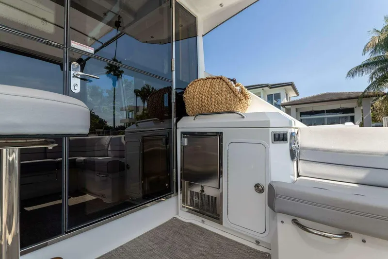 Slide: The Image of 2018 Cruisers Cantius 45 yacht interior with seating, glass doors, and outdoor view. - 10