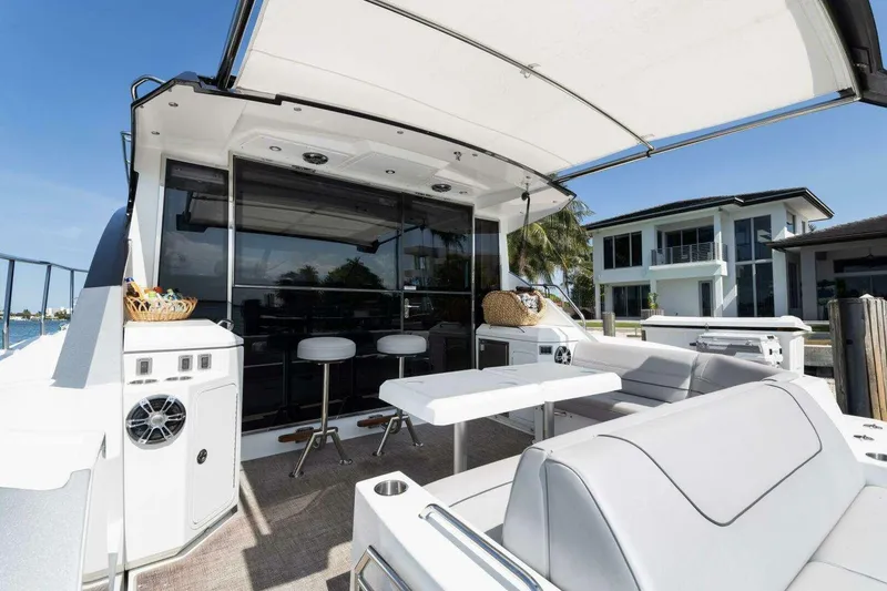Slide: The Image of 2018 Cruisers Cantius 45 yacht deck with seating, table, and waterfront view. - 8