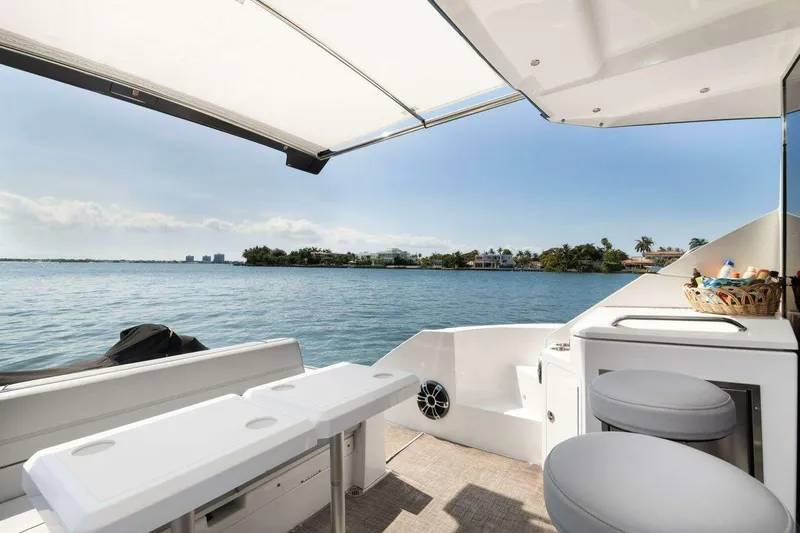 Slide: The Image of 2018 Cruisers Cantius 45 yacht deck with seating, table, and ocean view. - 9