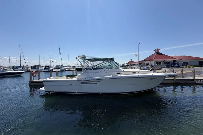 The Image of 1998 Pursuit 3400 Express boat docked at marina under clear blue sky. - 8