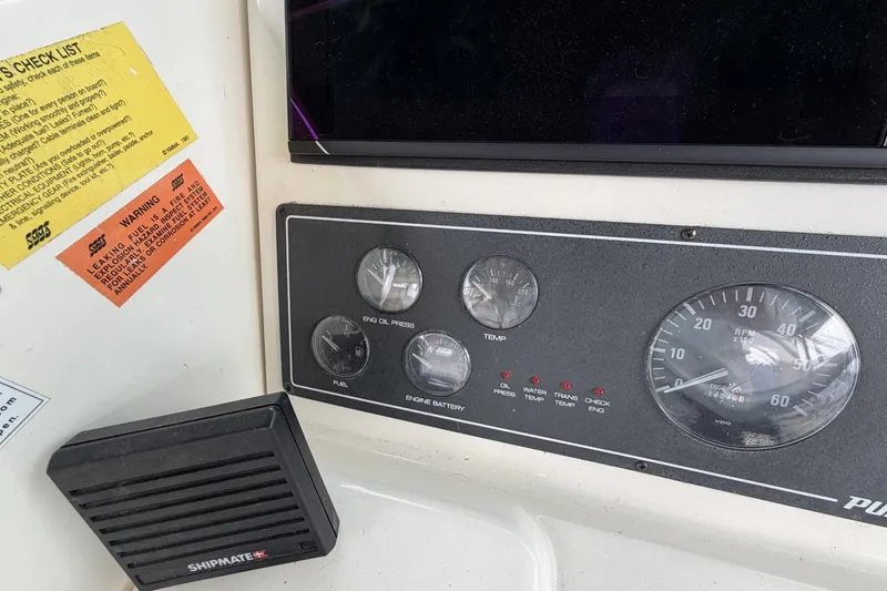 Slide: The Image of Control panel of a 1998 Pursuit 3400 Express boat with gauges and warning labels. - 11