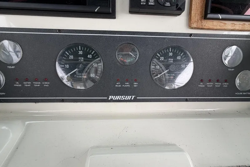 Slide: The Image of Dashboard of a 1998 Pursuit 3400 Express boat with gauges and indicators. - 12