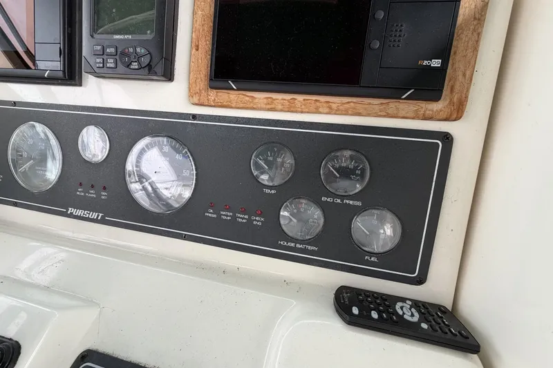 Slide: The Image of Dashboard of a 1998 Pursuit 3400 Express boat with gauges and controls. - 13