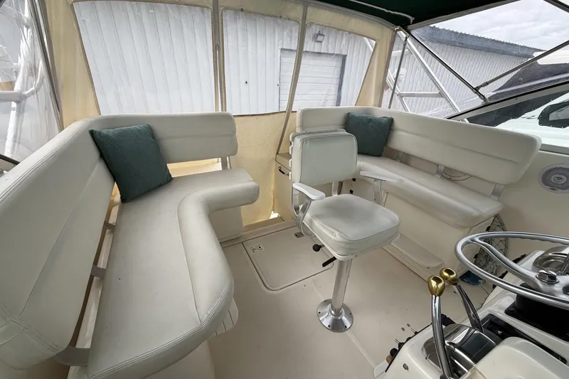 Slide: The Image of Interior of a 1998 Pursuit 3400 Express boat with white seating and helm. - 14