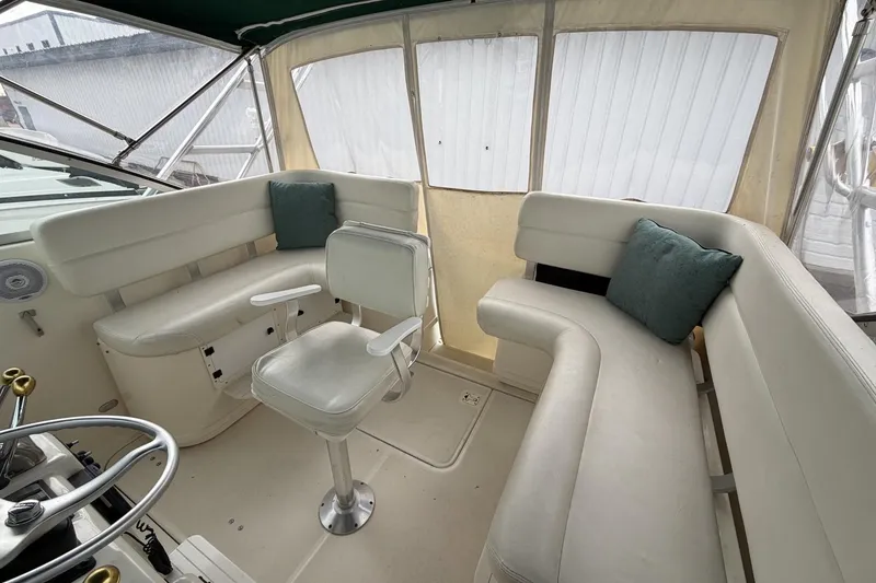 Slide: The Image of 1998 Pursuit 3400 Express boat interior with white seating and teal cushions. - 15