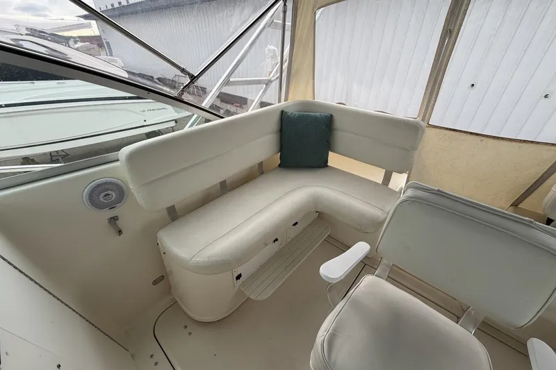 Slide: The Image of 1998 Pursuit 3400 Express boat interior with white seating and a teal cushion. - 17