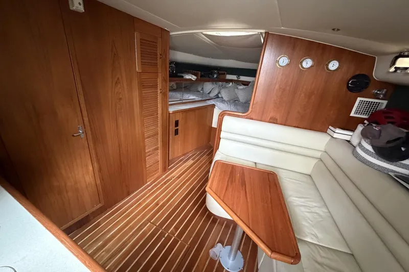 Slide: The Image of Interior of a 1998 Pursuit 3400 Express boat with wood paneling and seating. - 18
