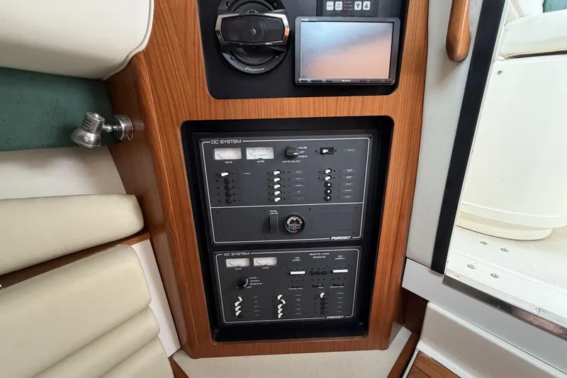 Slide: The Image of Control panel of a 1998 Pursuit 3400 Express boat with wood finish and electronic systems. - 20
