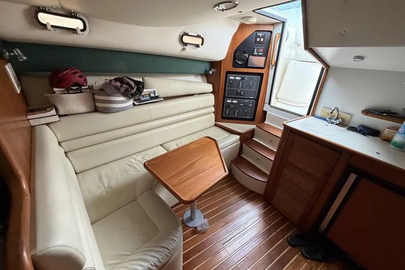 Slide: The Image of Interior of 1998 Pursuit 3400 Express boat with seating, table, and kitchenette. - 23