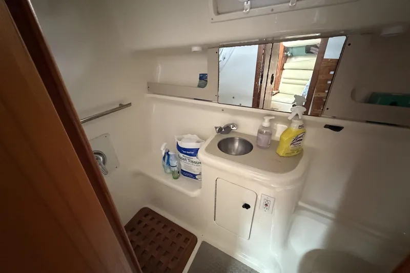 Slide: The Image of Bathroom interior of 1998 Pursuit 3400 Express boat with sink and cleaning supplies. - 25